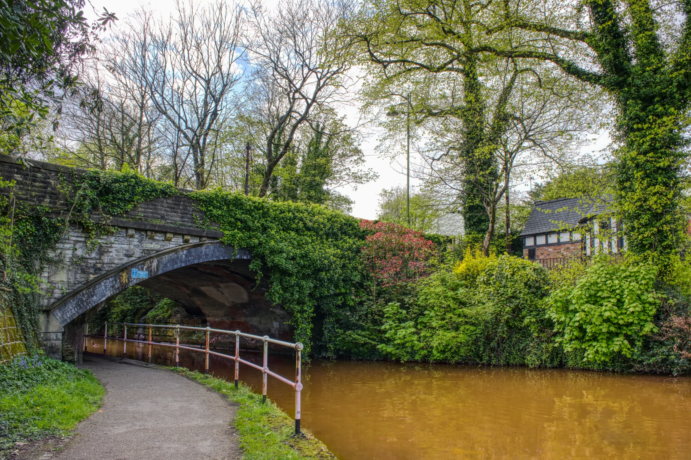 There's a strong chance this image contains the following subjects: tree,  architecture,  fall,  nature,  leaf,  river,  bridge,  park,  canal,  salford,  manchester,  greatermanchester. The photographer has provided the following description: Taken in Worsley, Greater Manchester of a bridge over the Bridgewater Canal. Photographer_name: Chris Michael. Title: Bridgewater Canal. The photographer has provided the following description: Taken in Worsley, Greater Manchester of a bridge over the Bridgewater Canal. Make: fujifilm. Model: X-T5. Technical: 16-80mm. Published: 2025-09-10 13:43:05