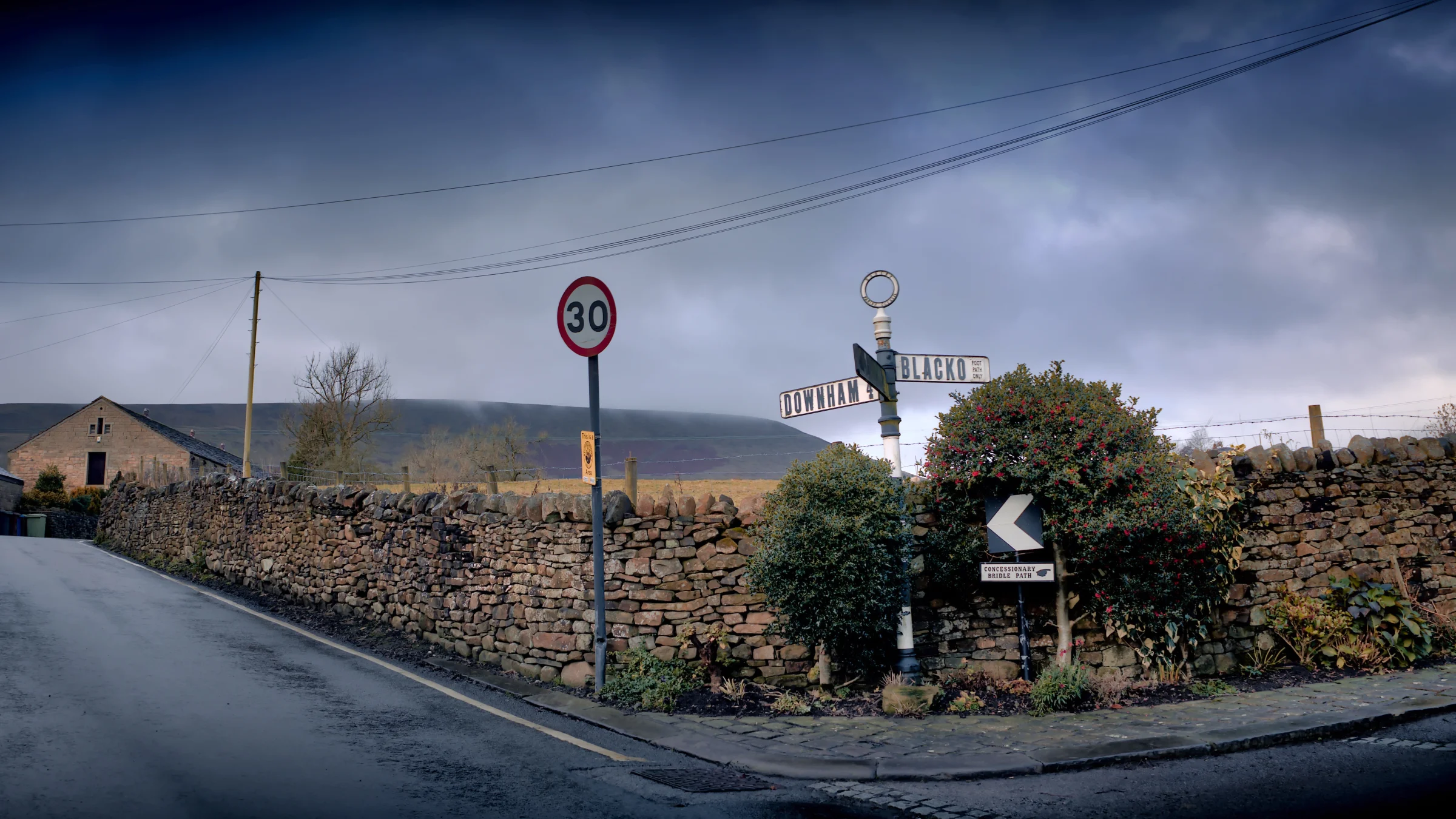 There's a strong chance this image contains the following subjects: street,  landscape,  travel,  road,  lancashire,  pendlehill,  storm. The photographer has provided the following description: Just before the storm hit us. Taken in Barley, Lancashire, with Pendle Hill in the distance. Photographer_name: Chris Michael. Title: Barley Storm. The photographer has provided the following description: Just before the storm hit us. Taken in Barley, Lancashire, with Pendle Hill in the distance. Make: canon. Model: EOS R. Technical: Canon RF16mm. Published: 2025-09-06 18:12:52