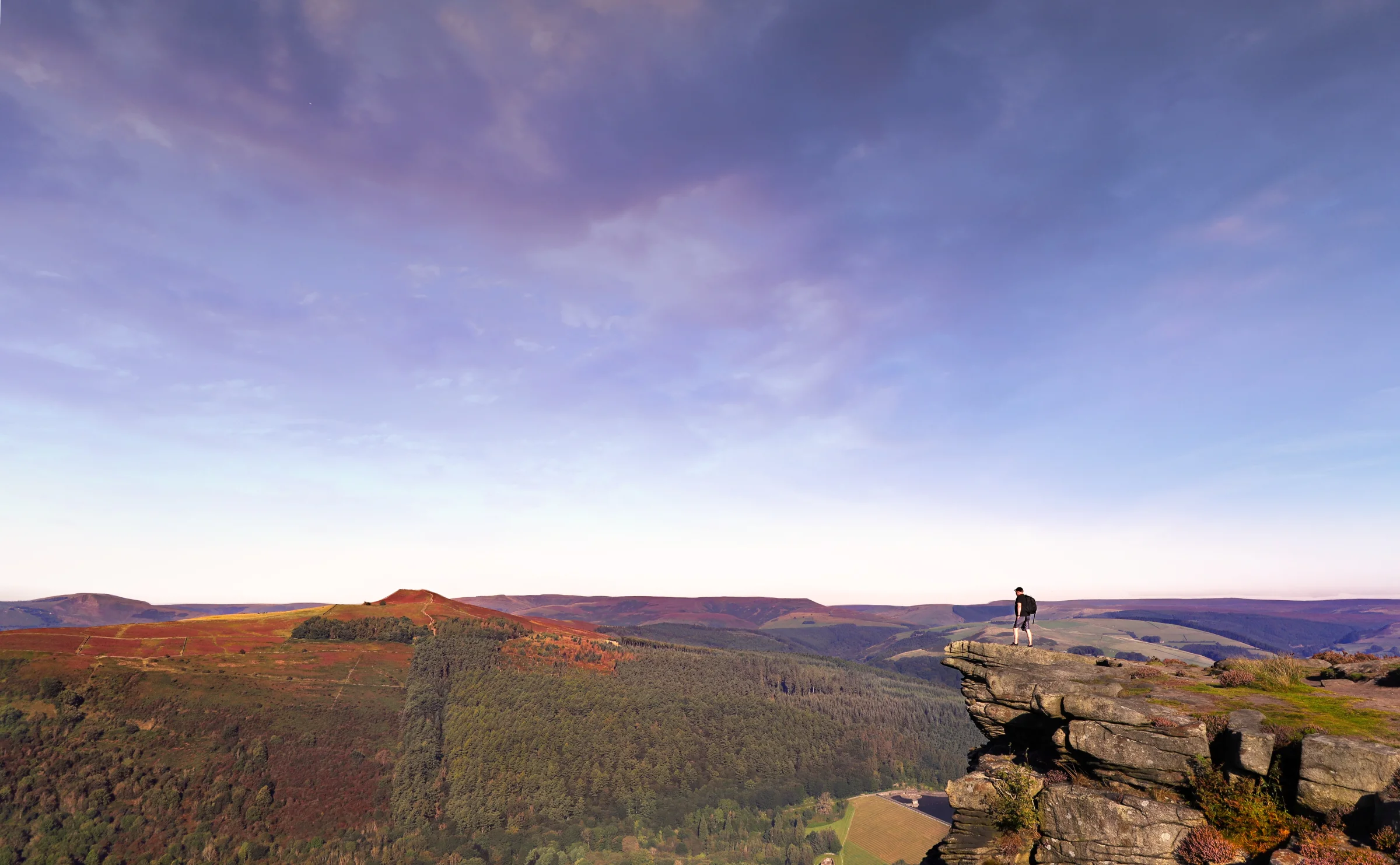 There's a strong chance this image contains the following subjects: sky,  landscape,  travel,  sunset,  nature,  peakdistrict,  chrismichael. The photographer has provided the following description: Here I am up high on Bamford Edge looking out across the Peak District and down towards Ladybower Reservoir  Photographer_name: Chris Michael. Title: Bamford Edge. The photographer has provided the following description: Here I am up high on Bamford Edge looking out across the Peak District and down towards Ladybower Reservoir  Make: canon. Model: EOS R. Technical: Canon RF16mm. Published: 2025-09-05 18:53:12