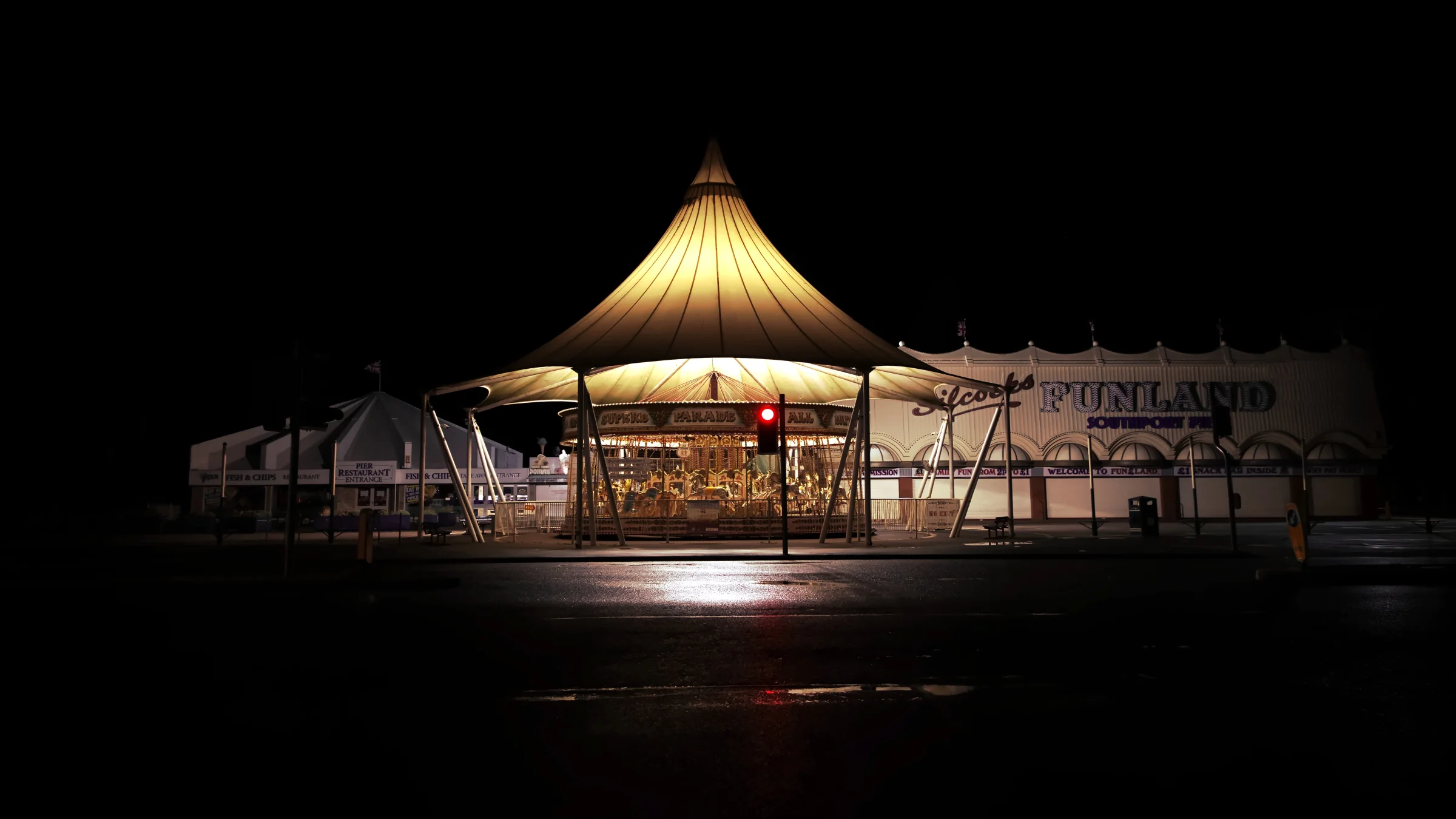 There's a strong chance this image contains the following subjects: architecture,  light,  water,  travel,  sea,  beach,  merseyside,  southport. The photographer has provided the following description: This is the fairground carousel off Marine Drive in Southport, Merseyside. Seen at night, closed down during winter. Spooky eh!? Photographer_name: Chris Michael. Title: The Fairground. The photographer has provided the following description: This is the fairground carousel off Marine Drive in Southport, Merseyside. Seen at night, closed down during winter. Spooky eh!? Make: fujifilm. Model: X-T5. Technical: 16-80mm. Published: 2025-09-07 22:27:53