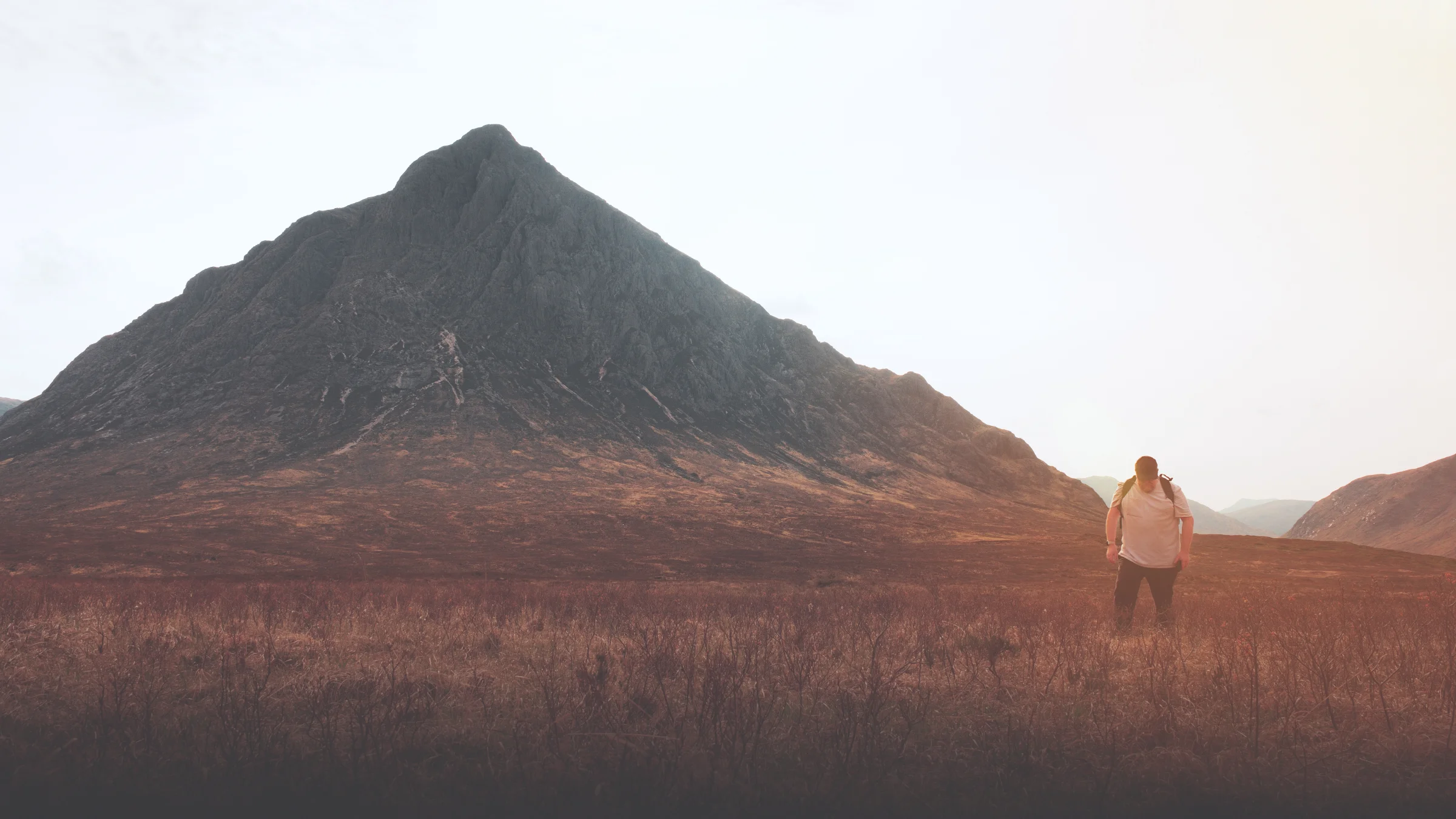 There's a strong chance this image contains the following subjects: sky,  landscape,  travel,  people,  sunset,  chrismichael,  scotland,  scottishhighlands,  buachailleetivemor,  glencoe. The photographer has provided the following description: Just me, walking in front of the beautiful Buachaille Etive Mor in the Scottish Highlands at sunset. Photographer_name: Chris Michael. Title: The Buckle. The photographer has provided the following description: Just me, walking in front of the beautiful Buachaille Etive Mor in the Scottish Highlands at sunset. Make: fujifilm. Model: X-T5. Technical: 16-80mm. Published: 2025-09-08 18:46:10