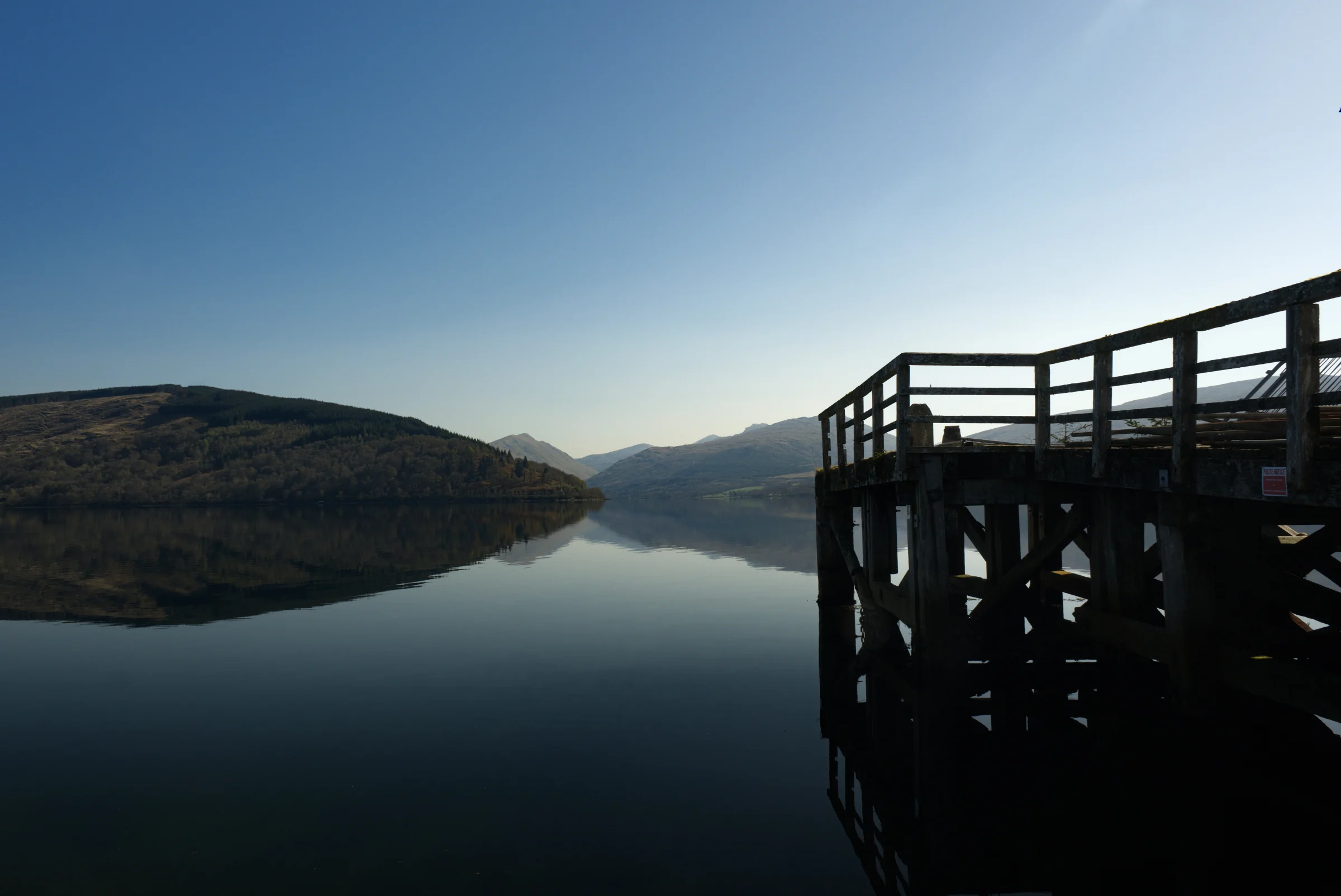 There's a strong chance this image contains the following subjects: sky,  water,  landscape,  lake,  travel,  sunset,  dawn,  river,  reflection,  bridge,  scotland,  scottishhighlands,  inveraray. The photographer has provided the following description: The beautiful seaside town of Inveraray in the Scottish Highlands Photographer_name: Chris Michael. Title: Inveraray Pier. The photographer has provided the following description: The beautiful seaside town of Inveraray in the Scottish Highlands Make: fujifilm. Model: X-T5. Technical: 16-80mm. Published: 2025-09-08 21:47:47
