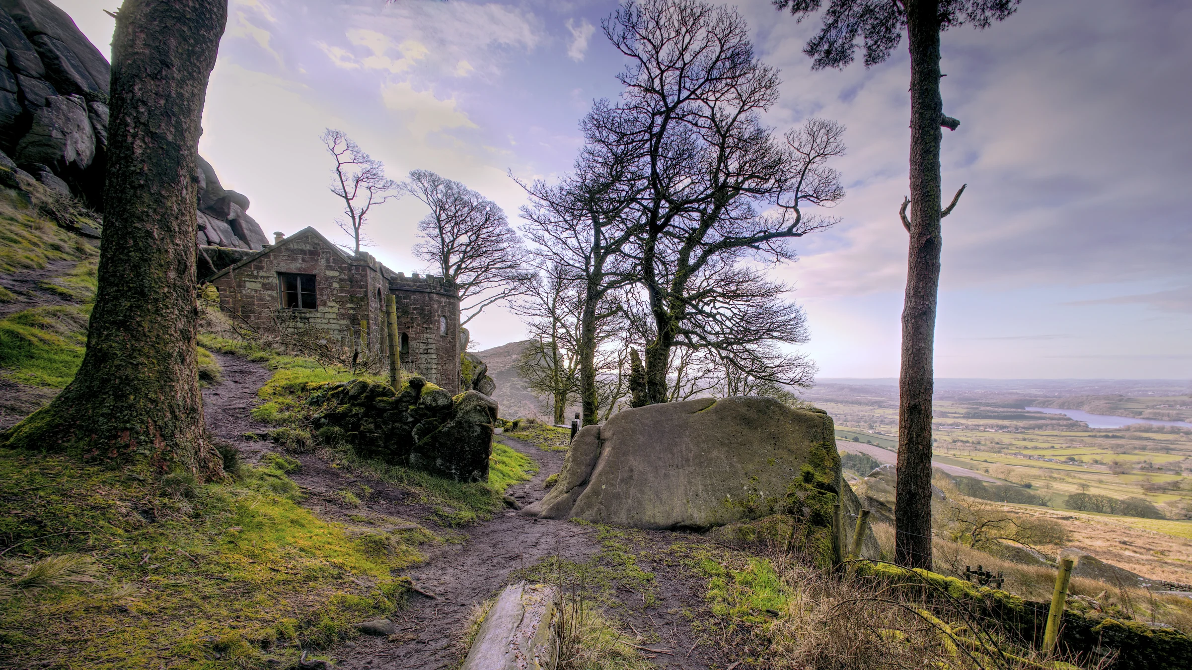 There's a strong chance this image contains the following subjects: tree,  sky,  landscape,  travel,  nature,  grass. The photographer has provided the following description: At the Roaches in Staffordshire. There's a hut in the woods! Photographer_name: Chris Michael. Title: The Roaches. The photographer has provided the following description: At the Roaches in Staffordshire. There's a hut in the woods! Make: canon. Model: EOS R. Technical: 16mm. Published: 2025-09-07 22:32:01