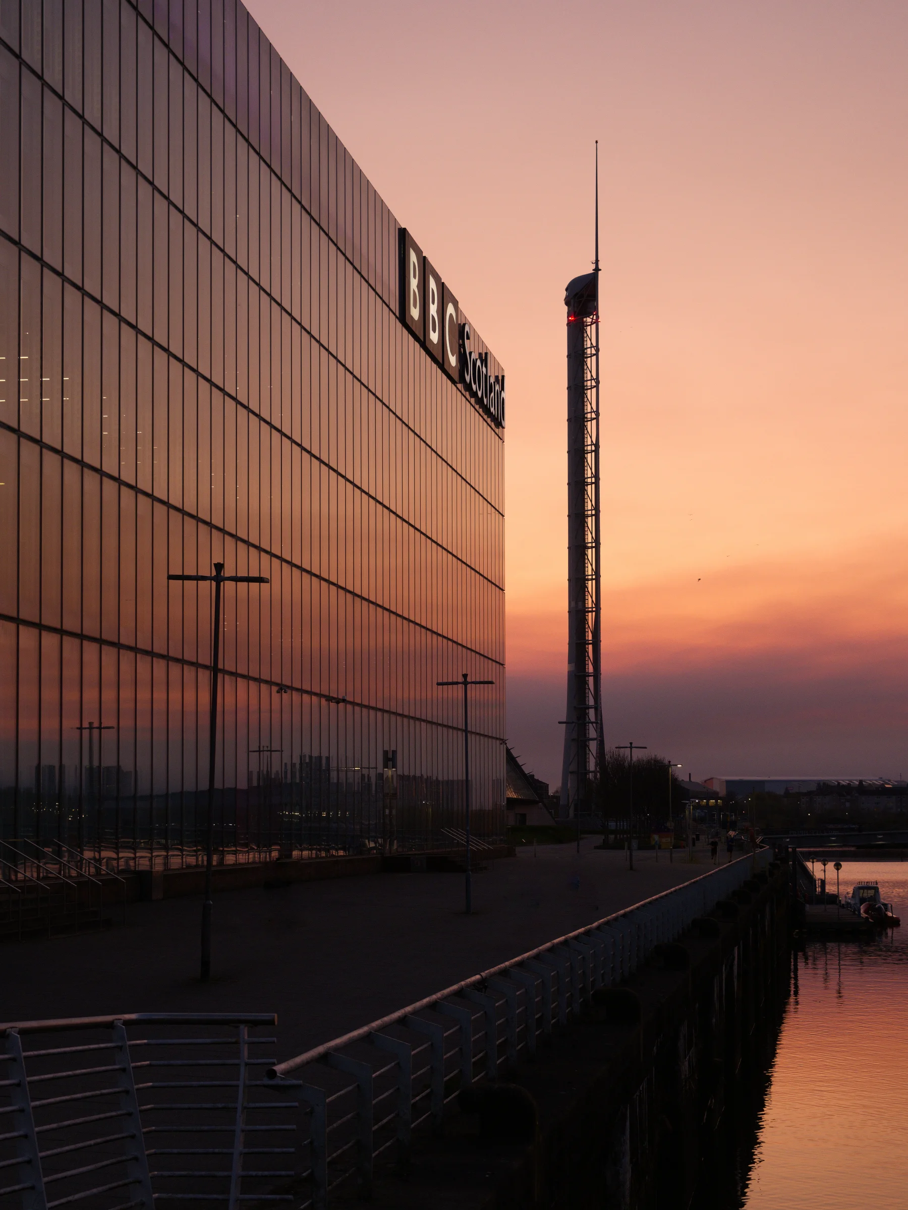There's a strong chance this image contains the following subjects: architecture,  sky,  water,  city,  sunset,  river,  bridge,  scotland,  glasgow. The photographer has provided the following description: Taken in Glasgow on a gorgeous late Spring evening in 2025. Photographer_name: Chris Michael. Title: BBC Scotland & The Science Tower. The photographer has provided the following description: Taken in Glasgow on a gorgeous late Spring evening in 2025. Make: fujifilm. Model: X-t5. Technical: 16-80mm. Published: 2025-09-08 18:36:43