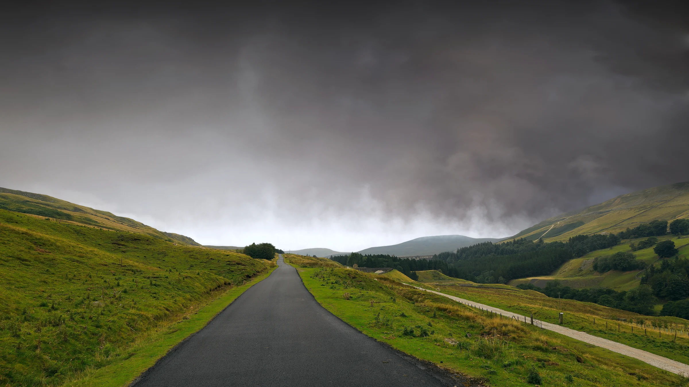 There's a strong chance this image contains the following subjects: landscape,  travel,  nature,  road,  storm,  rain,  yorkshire. The photographer has provided the following description: In the Nidderdale AONB, this road led us straight into a storm. Photographer_name: Chris Michael. Title: The Road to the Storm. The photographer has provided the following description: In the Nidderdale AONB, this road led us straight into a storm. Make: canon. Model: EOS R. Technical: 16MM. Published: 2025-09-07 23:29:54