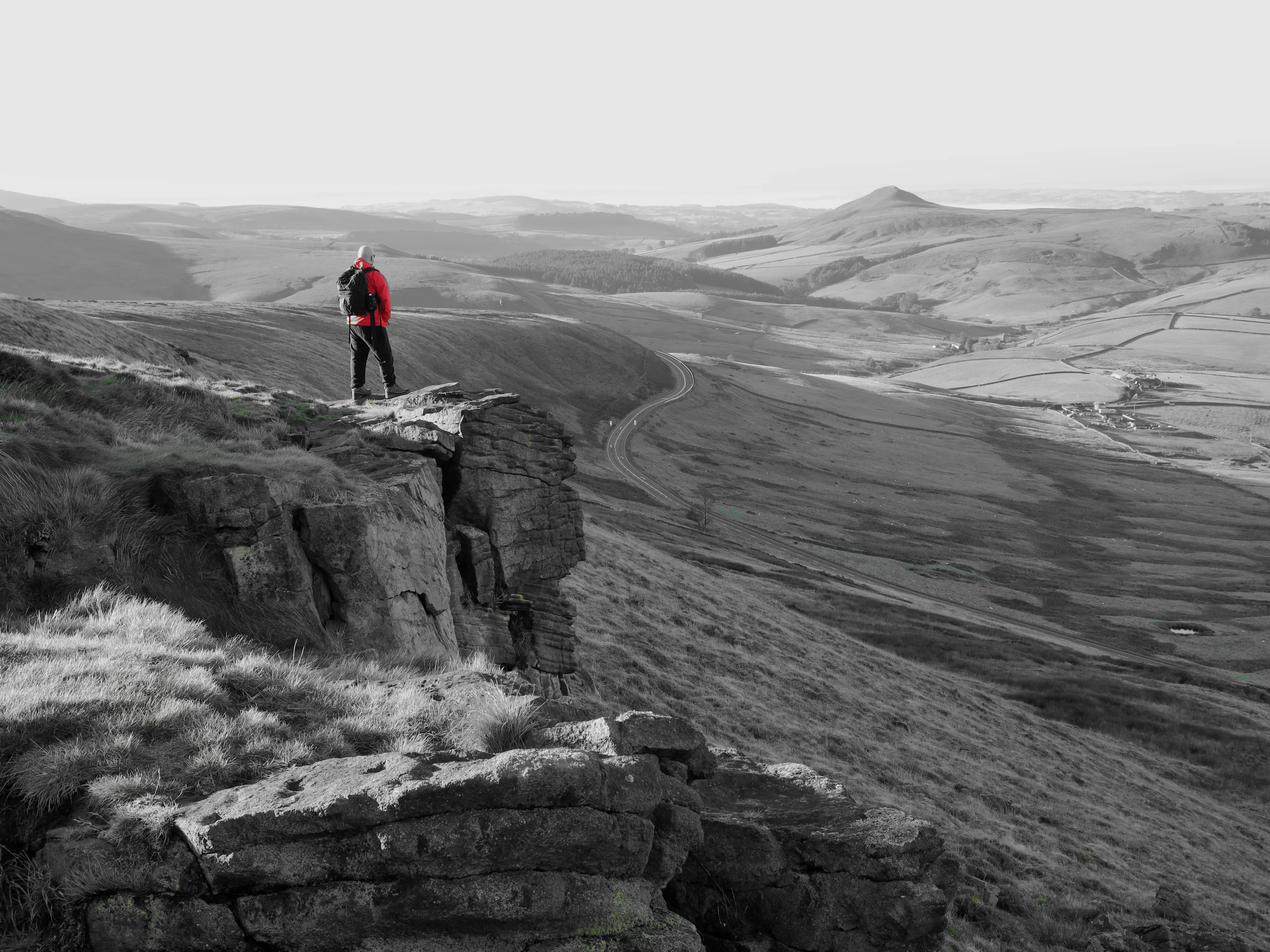 There's a strong chance this image contains the following subjects: landscape,  people,  chrismichael,  cheshire,  blackandwhite. The photographer has provided the following description: Standing high up on Shining Tor in Cheshire, looking out towards Shutlingsloe. Photographer_name: Chris Michael. Title: Shining Tor. The photographer has provided the following description: Standing high up on Shining Tor in Cheshire, looking out towards Shutlingsloe. Make: canon. Model: Canon EOS R. Technical: Canon RF16mm.. Published: 2025-09-05 19:03:02