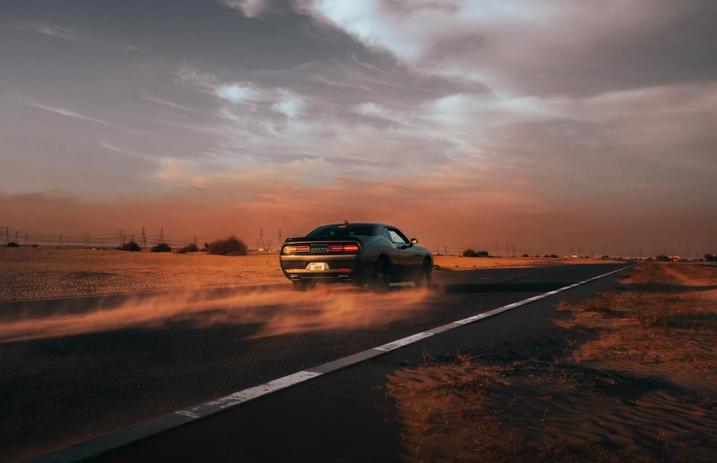 There's a strong chance this image contains the following subjects: sunset,  road,  car,  vehicle. The photographer has provided the following description: Something different from my usual style! Source: https://www.instagram.com/picsbydash/ Photographer_name: Dasha Butler. Title: Burning Rubber. The photographer has provided the following description: Something different from my usual style! Make: nikon. Model: z7ii. Published: 2025-10-12 10:15:30