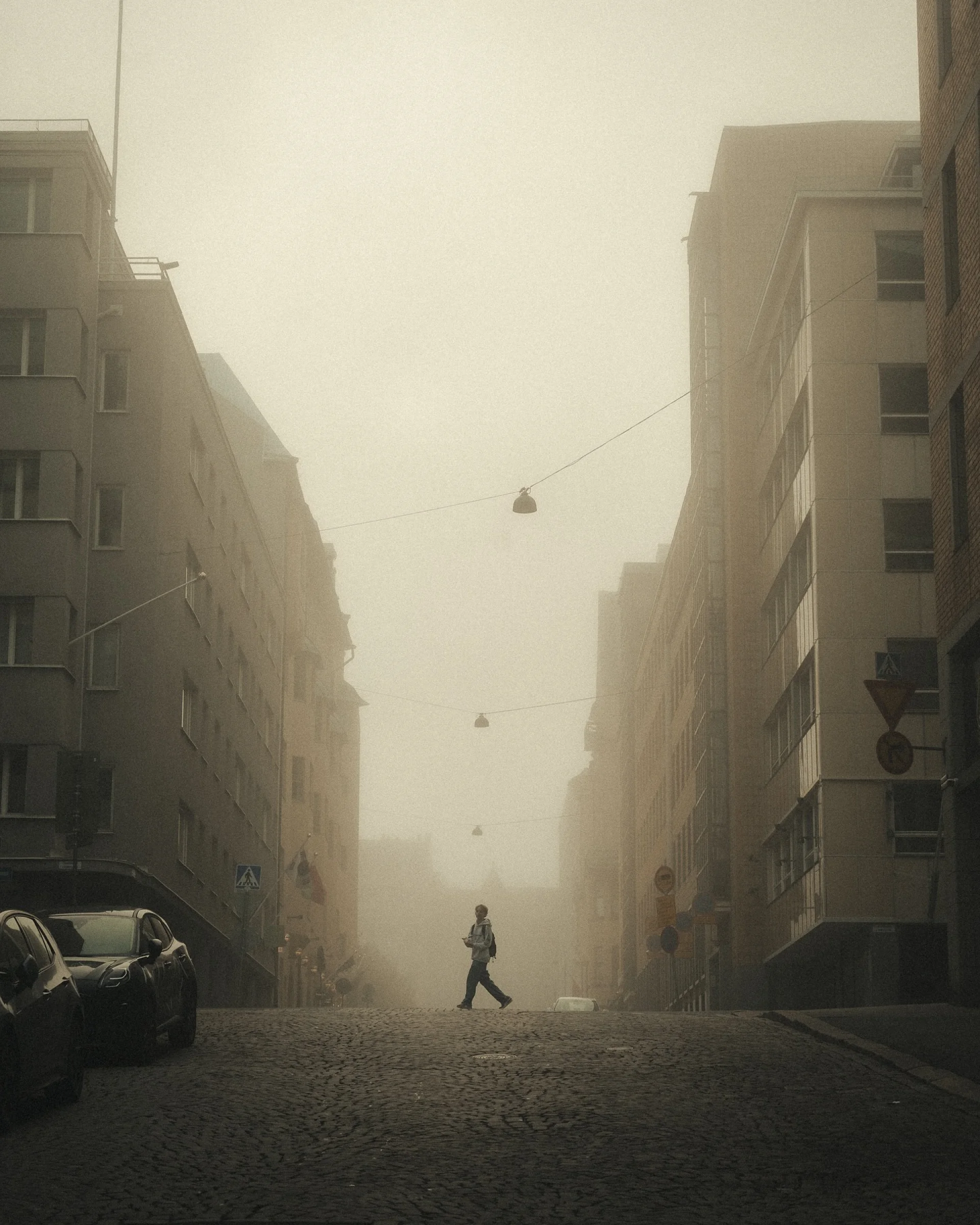 There's a strong chance this image contains the following subjects: street,  fog,  city. Source: https://www.instagram.com/pekkavalitalo/ Photographer_name: Pekka Välitalo. Title: Last shades of light. Make: sony. Model: a7 IV. Published: 2025-10-12 15:39:26