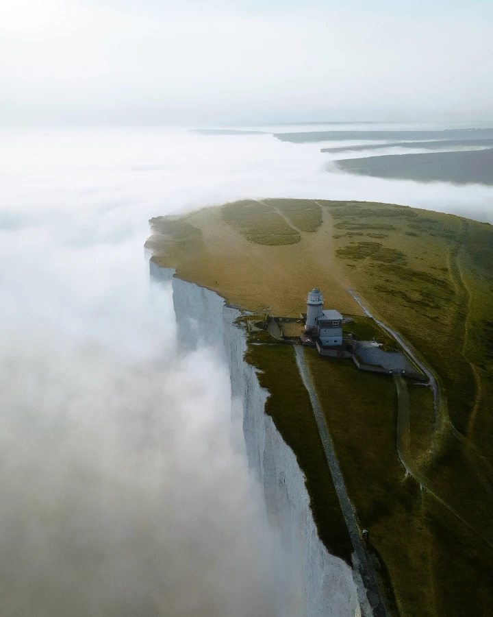There's a strong chance this image contains the following subjects: fog,  water,  landscape,  travel,  mist,  sea,  lighthouse. FOTO has this to say about the photograph: Captivating and inspiring photograph of the Belle Tout Lighthouse in Eastbourne, UK. The fog creates a surreal atmosphere and makes the land pop. Source: https://www.instagram.com/bryanlens_/ Photographer_name: Bryan. Title: A beacon of beauty. FOTO has this to say about the photograph: Captivating and inspiring photograph of the Belle Tout Lighthouse in Eastbourne, UK. The fog creates a surreal atmosphere and makes the land pop. Published: 2025-06-13 15:34:28