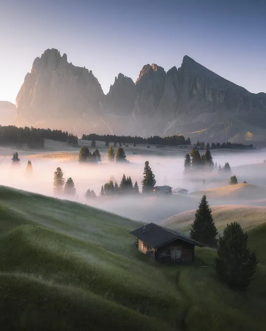 There's a strong chance this image contains the following subjects: fog,  landscape,  travel,  mist,  sunset,  evening. FOTO has this to say about the photograph: This photograph beautifully captures a quiet, lived-in moment. The warm light spilling across layered textures and neutral tones creates an atmosphere of gentle comfort. Thoughtful composition draws the eye through the space naturally, revealing subtle details. It feels like a pause in time, inviting, grounded, and quietly reflective. Source: https://www.instagram.com/bleroncaka_photography/ Photographer_name: Bleron Çaka. Title: Morning mood at Alpe di Siusi. FOTO has this to say about the photograph: This photograph beautifully captures a quiet, lived-in moment. The warm light spilling across layered textures and neutral tones creates an atmosphere of gentle comfort. Thoughtful composition draws the eye through the space naturally, revealing subtle details. It feels like a pause in time, inviting, grounded, and quietly reflective. Published: 2025-06-25 09:20:38