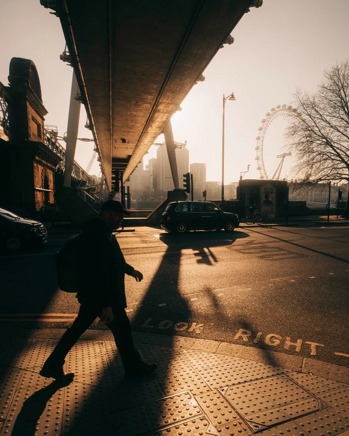 There's a strong chance this image contains the following subjects: street,  light,  travel,  city,  people,  sunset. FOTO has this to say about the photograph: Wonderful tones and sense of largeness, with classic London landmarks (The Eye and black cabs) from this set of photographs taken in London, UK, by photographer Samuel Bassett. Source: https://www.instagram.com/opticalwander/ Photographer_name: Samuel Bassett. Title: 20 Frames of a London Sunrise. FOTO has this to say about the photograph: Wonderful tones and sense of largeness, with classic London landmarks (The Eye and black cabs) from this set of photographs taken in London, UK, by photographer Samuel Bassett. Published: 2025-06-13 15:42:10