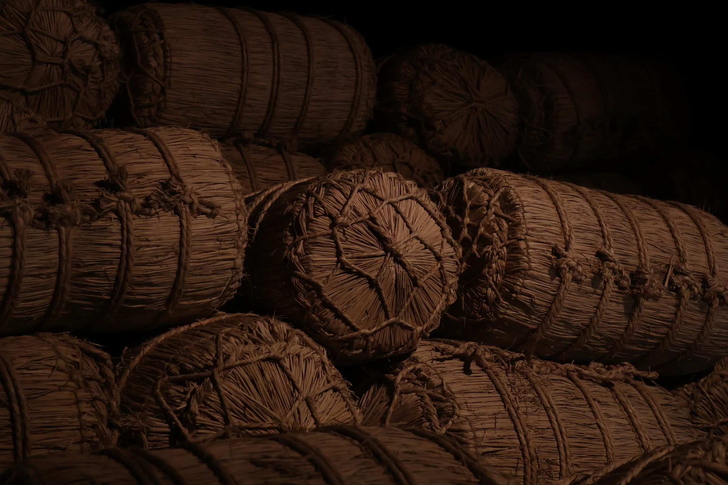 The photographer has provided the following description: Photographed in Takayama, Japan, this image captures a stack of traditionally wrapped straw bales. The directional lighting brings out the texture of the natural materials and highlights the craft of traditional Japanese storage techniques. Photographer_name: Abel Schellekens. Title: Straw Shadows. The photographer has provided the following description: Photographed in Takayama, Japan, this image captures a stack of traditionally wrapped straw bales. The directional lighting brings out the texture of the natural materials and highlights the craft of traditional Japanese storage techniques. Make: canon. Model: R50. Technical: f/5.0  1/50s  44mm  2500ISO. Published: 2026-06-19 08:40:08