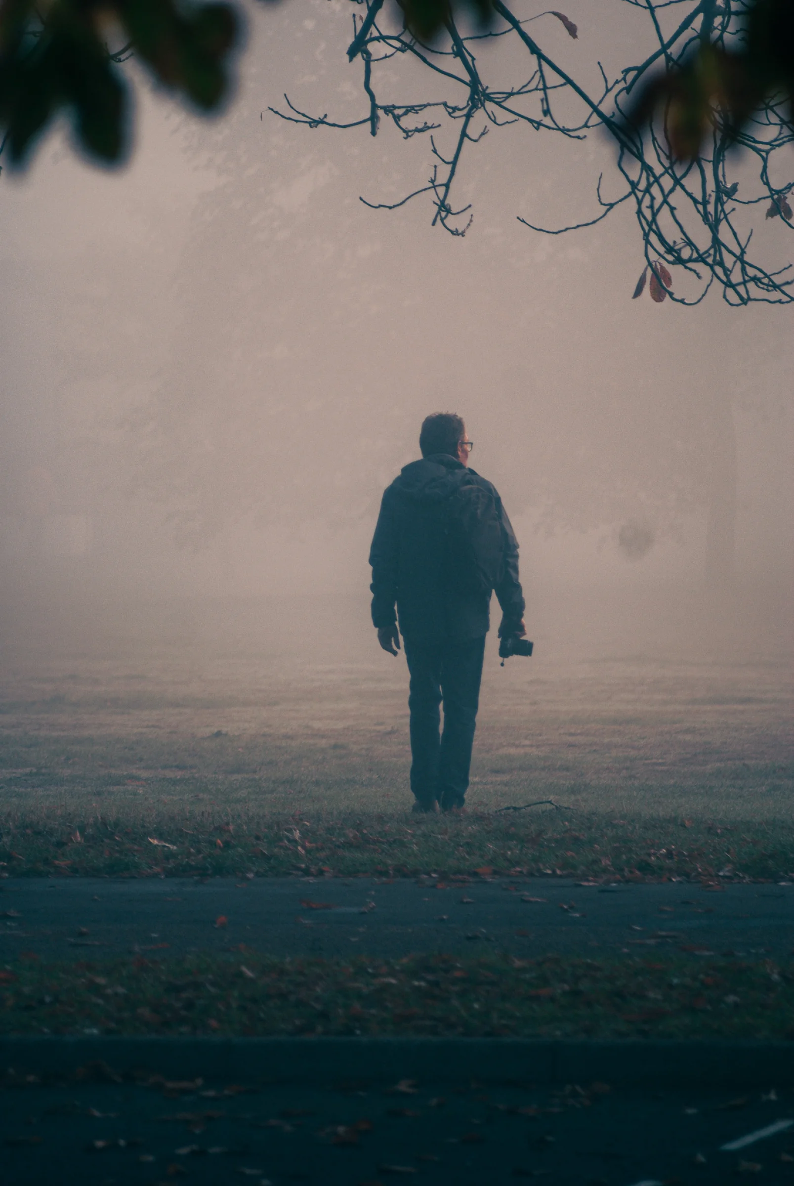There's a strong chance this image contains the following subjects: fog,  landscape,  people,  man,  london. The photographer has provided the following description: An early morning walk through Greenwich Park, and spotted another photographer in the wild. The fog creating some wonderful depth & contrast. Photographer_name: Lee Sillery. Title: Photographer in the mist. The photographer has provided the following description: An early morning walk through Greenwich Park, and spotted another photographer in the wild. The fog creating some wonderful depth & contrast. Make: sony. Model: a300. Technical: 200mm (100-200mm), f4.5, 1/200 SEC @ ISO 100. Published: 2025-09-29 10:36:16